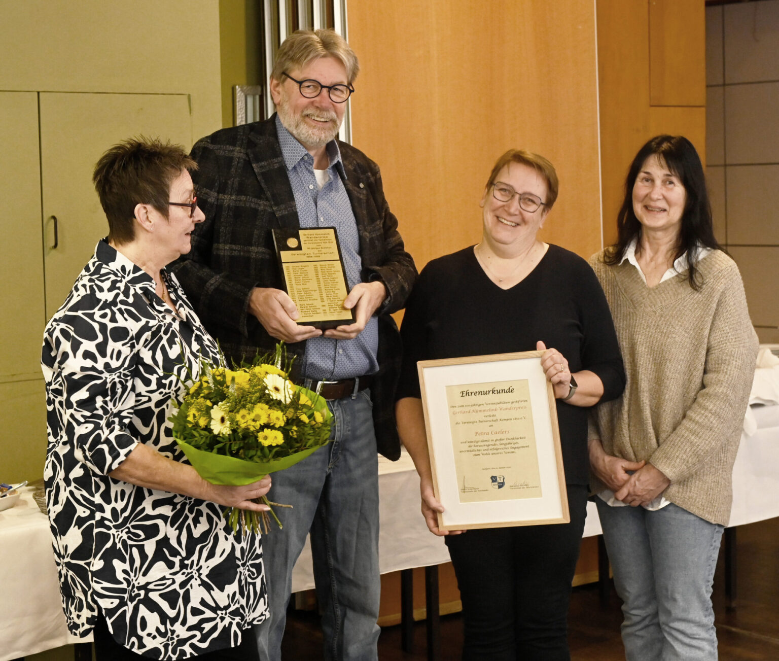 Ehrenurkunde, Pokal und Blumen überreichen anlässlich der Verleihung des Gerhard-Hümmelink-Wanderpreises der Vereinigten Turnerschaft Kempen Vorsitzender Detlev Schürmann und die Vorstandsmitglieder Marie-Luise Fehrenbach-Nagels (r.) und Heike Schürmann an Petra Caelers.